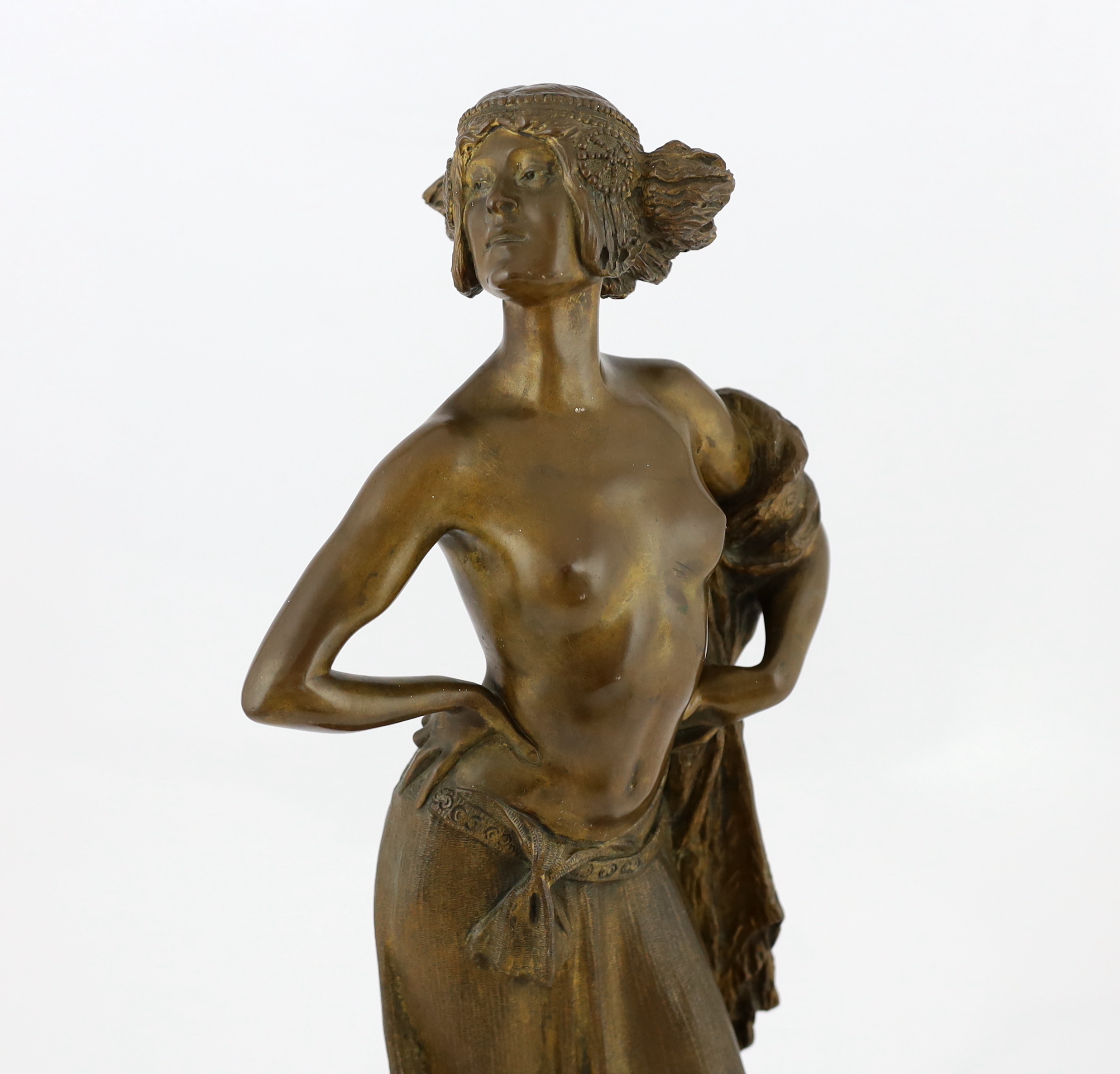 E. Leger - a bronze figure of an Eastern dancer standing with her hands on her hips, signed in the bronze, on rouge marble socle, 53cm high